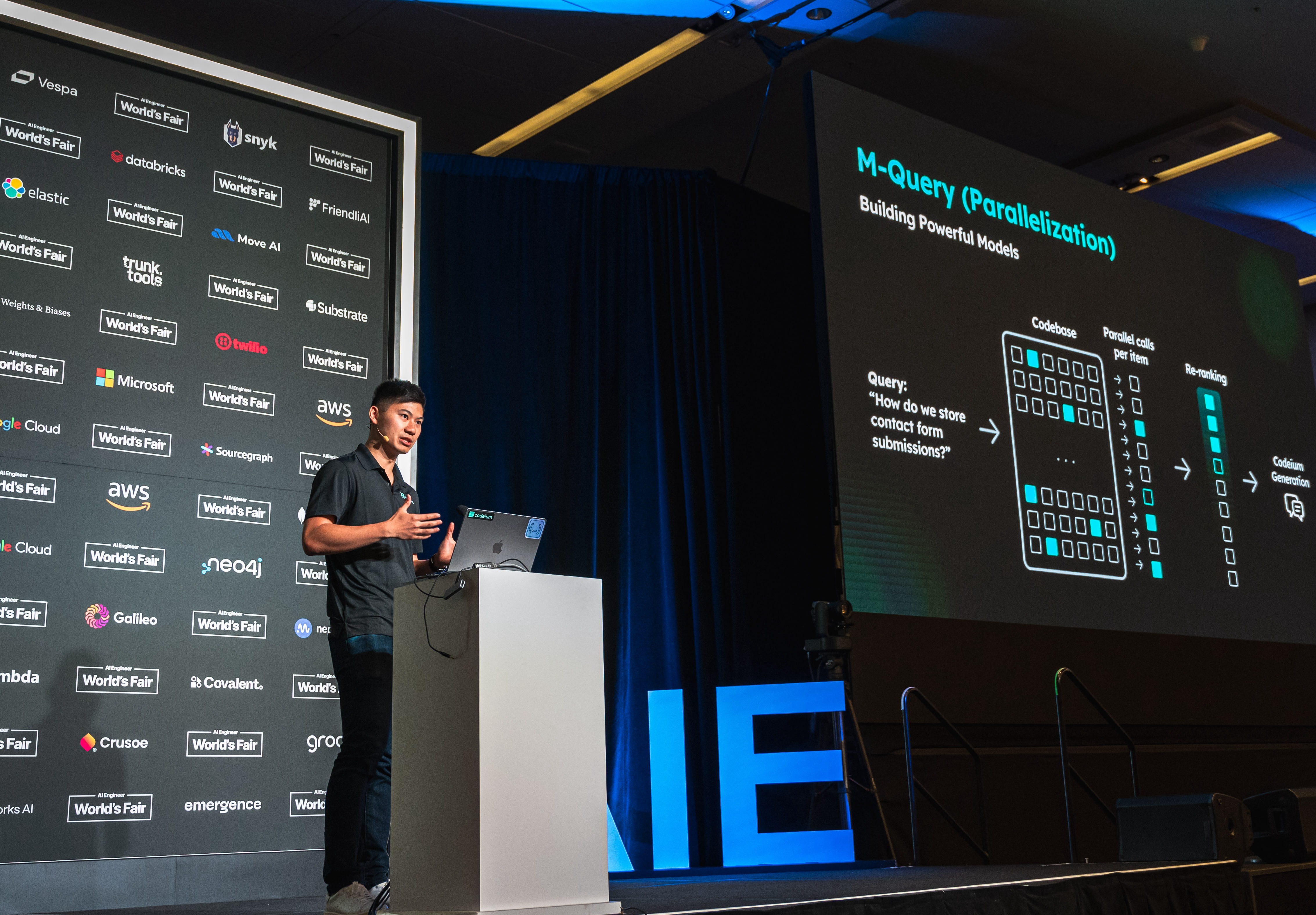 Kevin Hou presenting on a conference stage about M-Query Parallelization